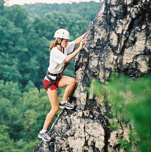 A female camper mountain climbing.