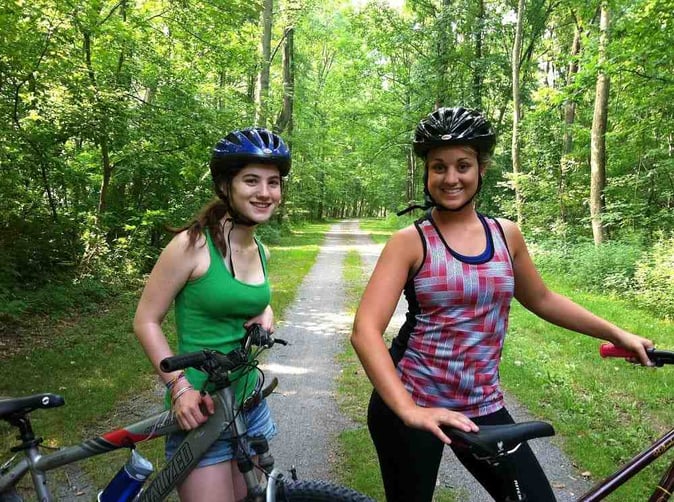 2 female Campers with bikes pose for a picture