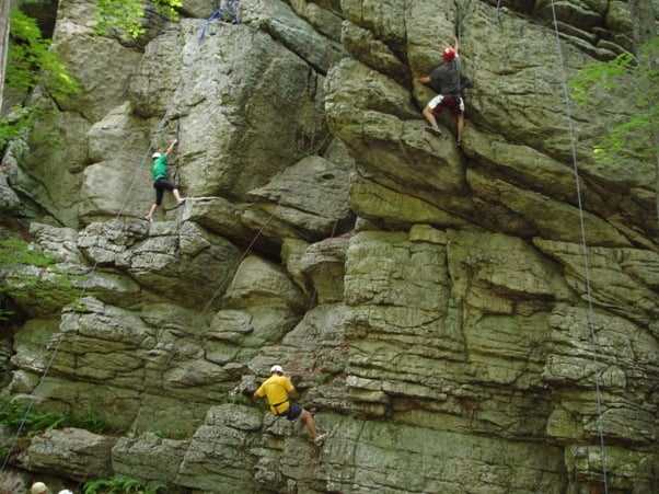 3 male Climbers rock climbing