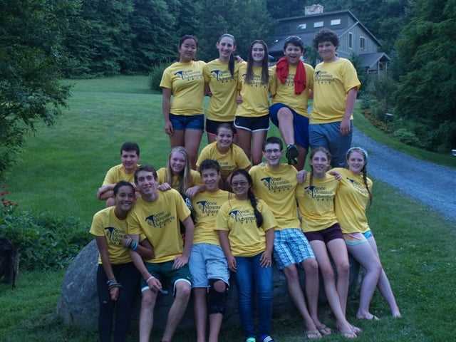 A group of teen Campers in the camp t-shirt pose for a picture. 