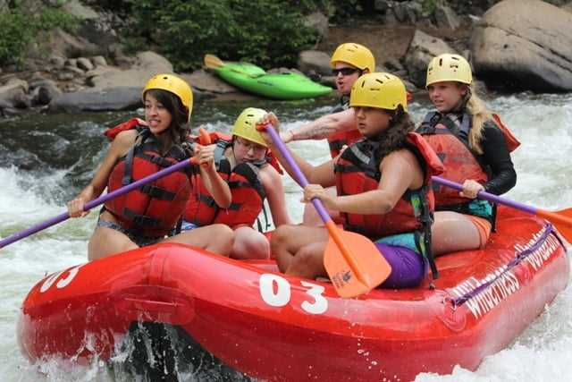 A group of teen Campers river rafting.