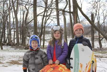 3 teen Campers pose for a picture with their surfboard.