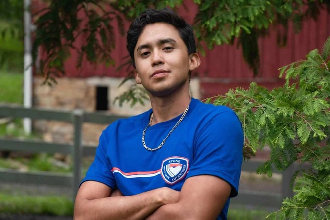 A male Camper pose for a picture in SMA T-shirt