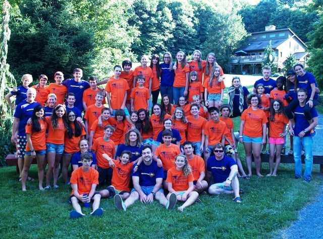 A group of teen Campers and Staff in camp t-shirts pose for a picture.