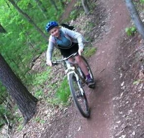 A female Camper riding bike up the hills.