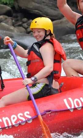 A Camper paddling her way off the white water