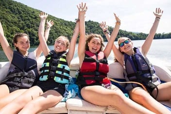 4 Teen Campers pose for a picture on a ship.