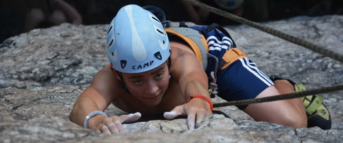 A male teen Camper rock climbing.