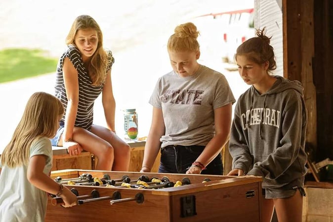 A group of female Teen Campers playing Table Soccer.