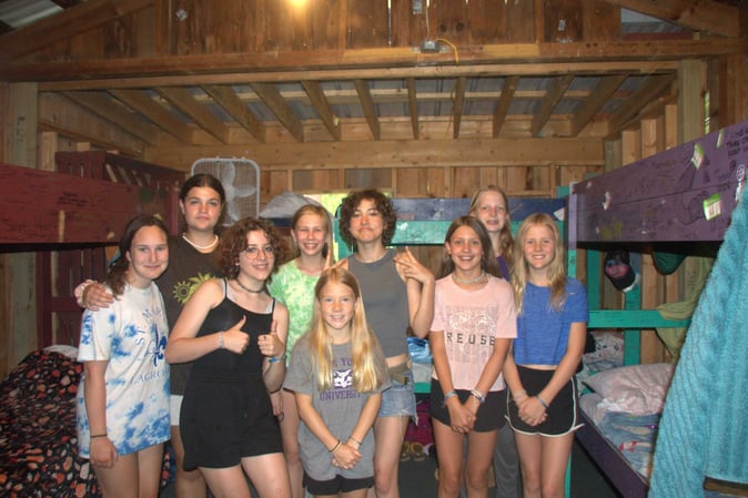A group of Teen female Campers pose for a picture in their dormitory..