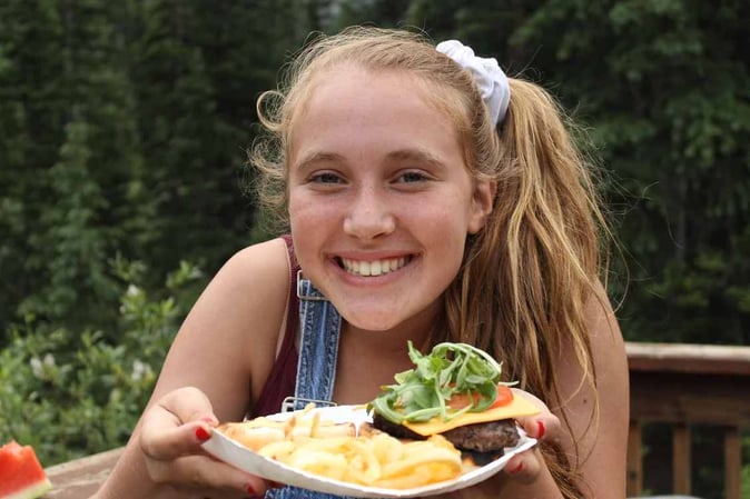 A camper posing with her meal.
