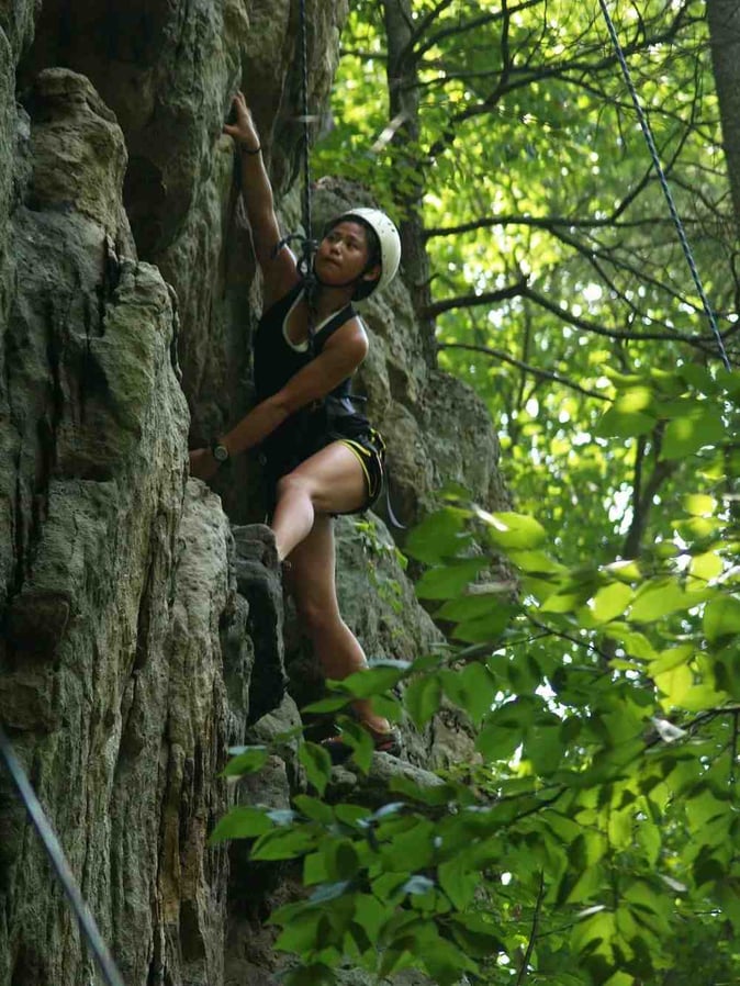 A female Camper rock climbing