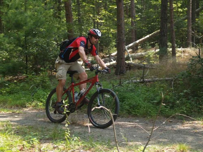 Another male Camper with his head up while descending from the mountain with his bike.