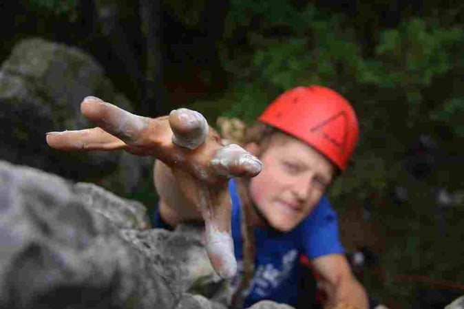 A male Camper rock climbing