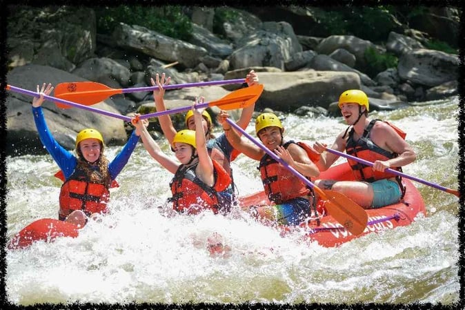 A group of Campers white water rafting pose for a picture