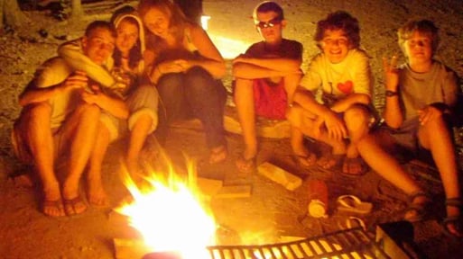 A group of Campers warming up by the fire