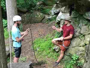 2 Campers having a conversation while getting ready to rock climb