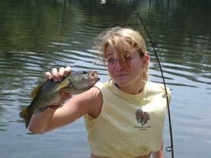 A Female Camper holding up the fish she caught. 