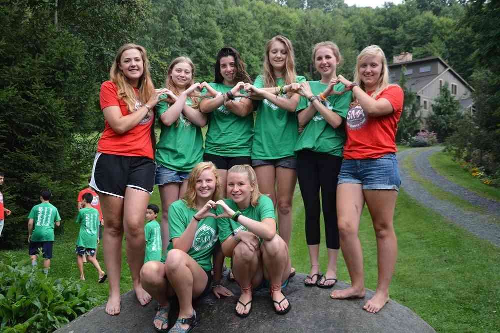 A group of female Campers pose for a group picture in SMA T-shirt