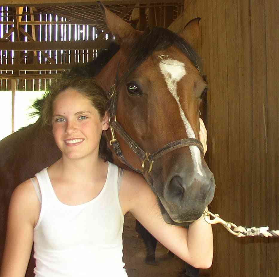 A female Camper pose with a horse